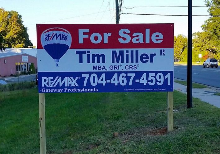 A real estate for-sale Panel sign by REMAX featuring real estate agent